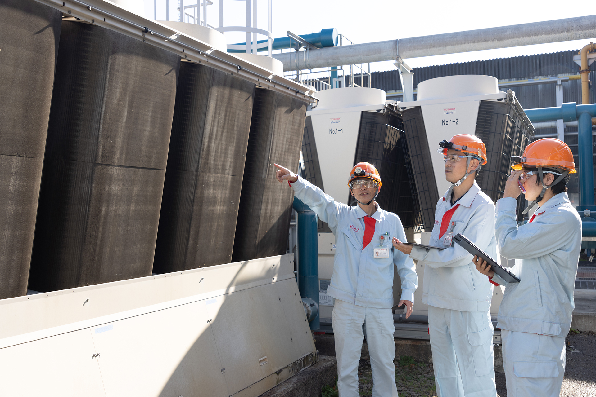 設備の前で相談し合う社員たち