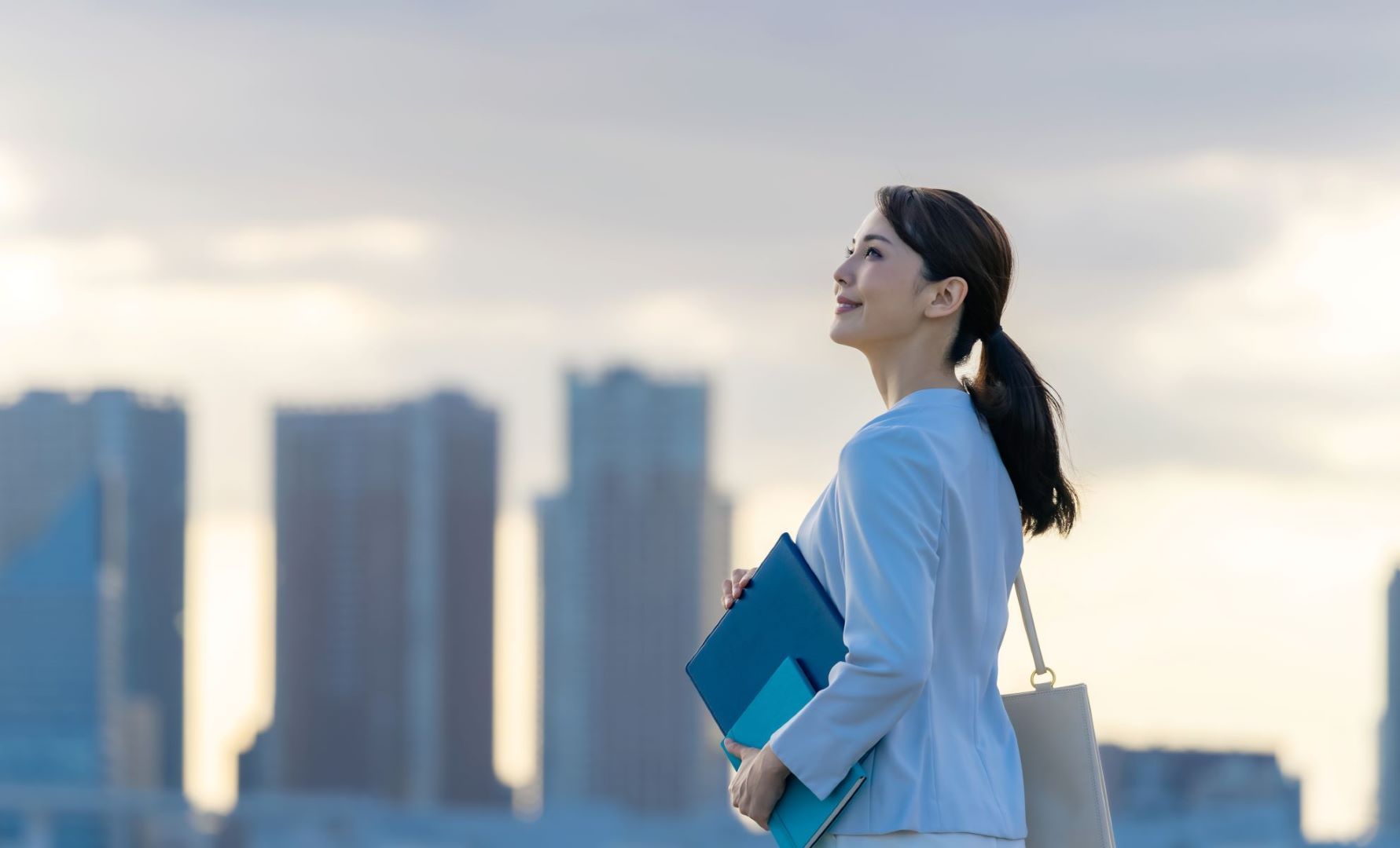 スーツを着て空を見上げる女性