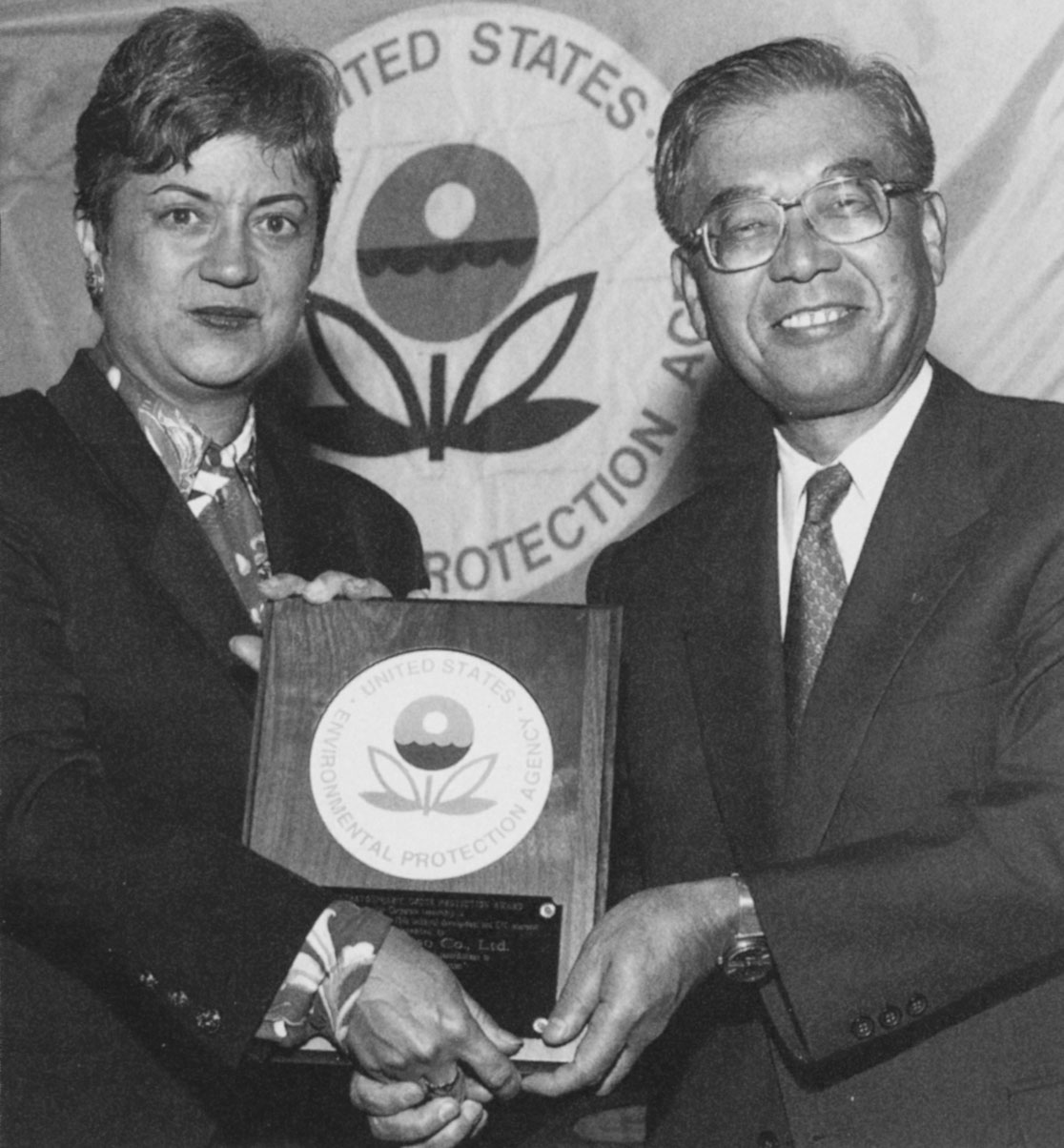 DENSO Manufacturing Michigan (DMMI) president Sam Kawai accepts the 1993 Stratospheric Ozone Protection Award from a U.S. Environmental Protection Agency official.