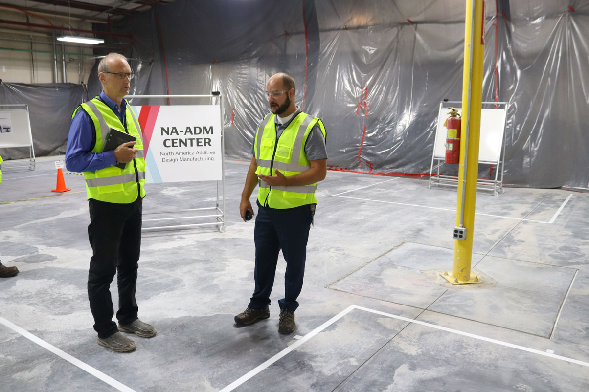 Senior Vice President Dave Grimmer (left) receives an update on the North America Additive Design Manufacturing expansion in August 2021.