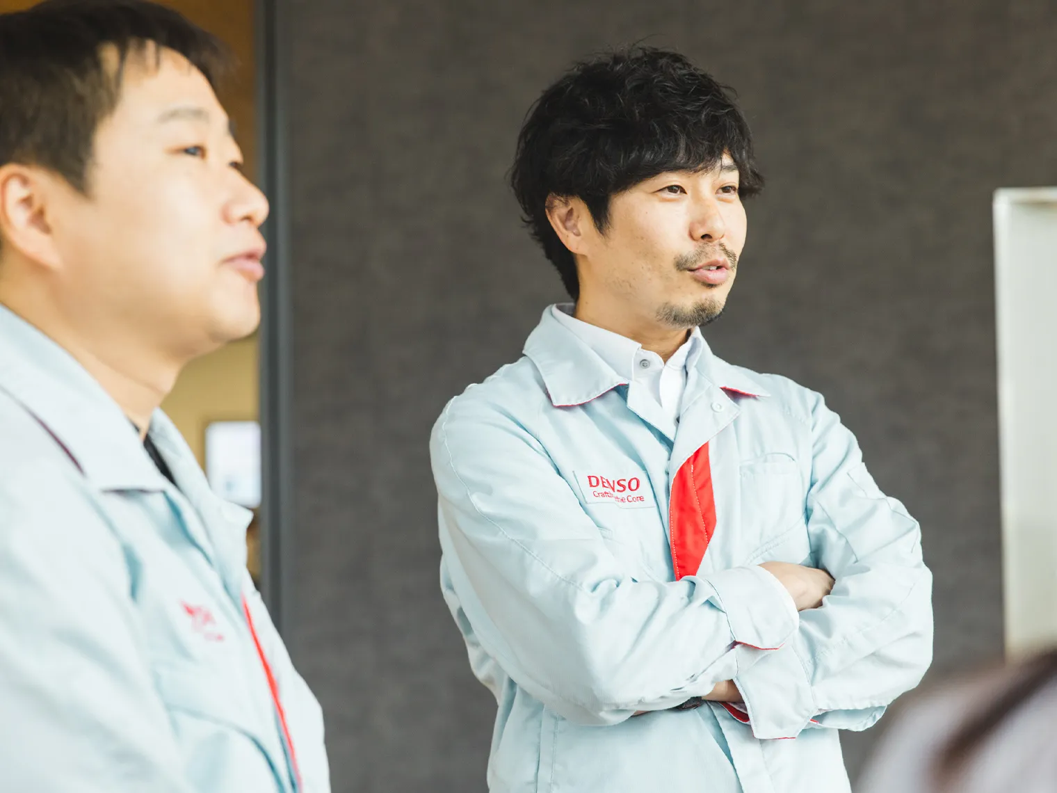 ASIC技術部の吉田、梶本が腕を組んで話を聞いている様子