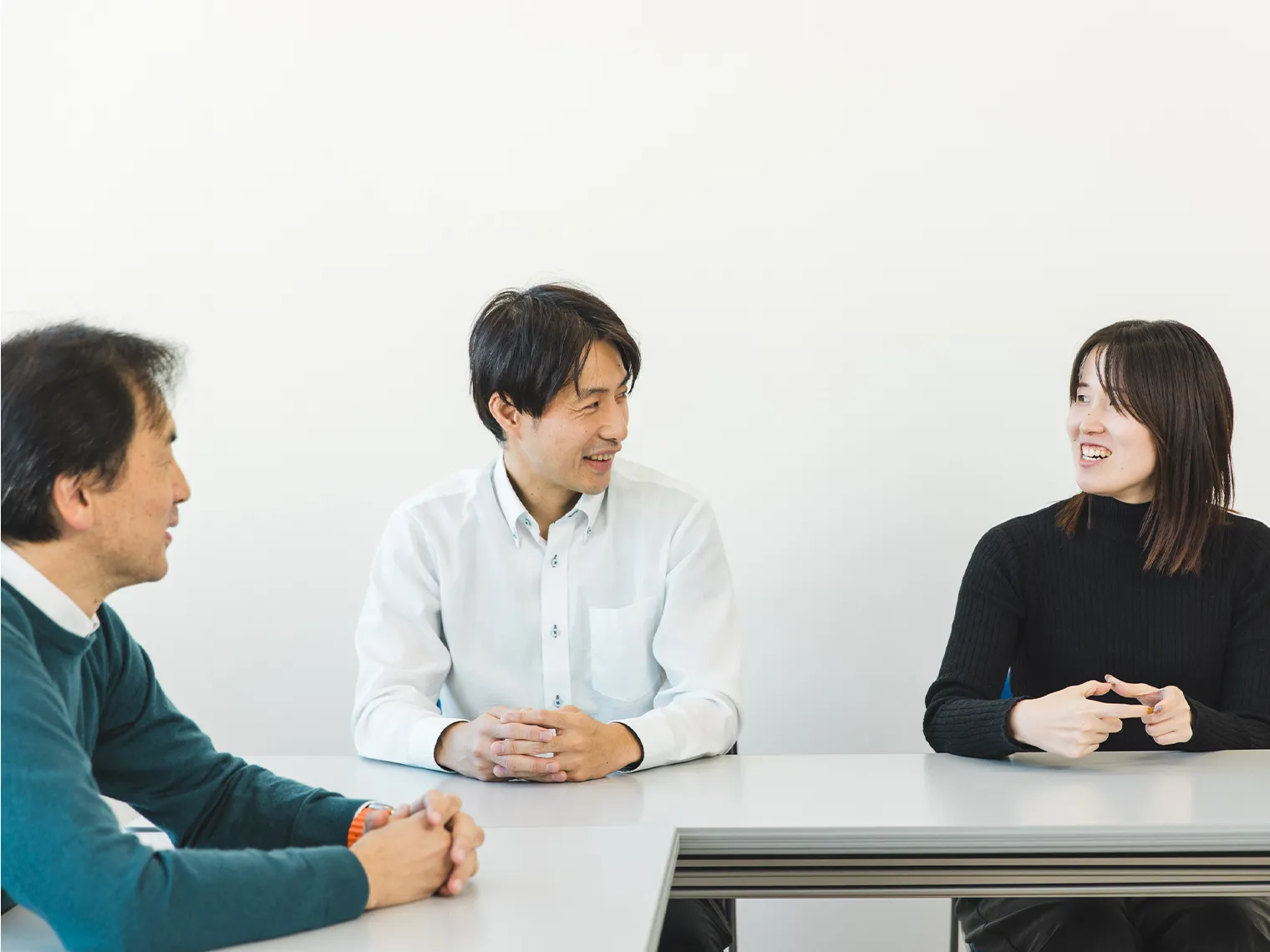 会議室でディスカッションする稲葉、坂根、安部の3名