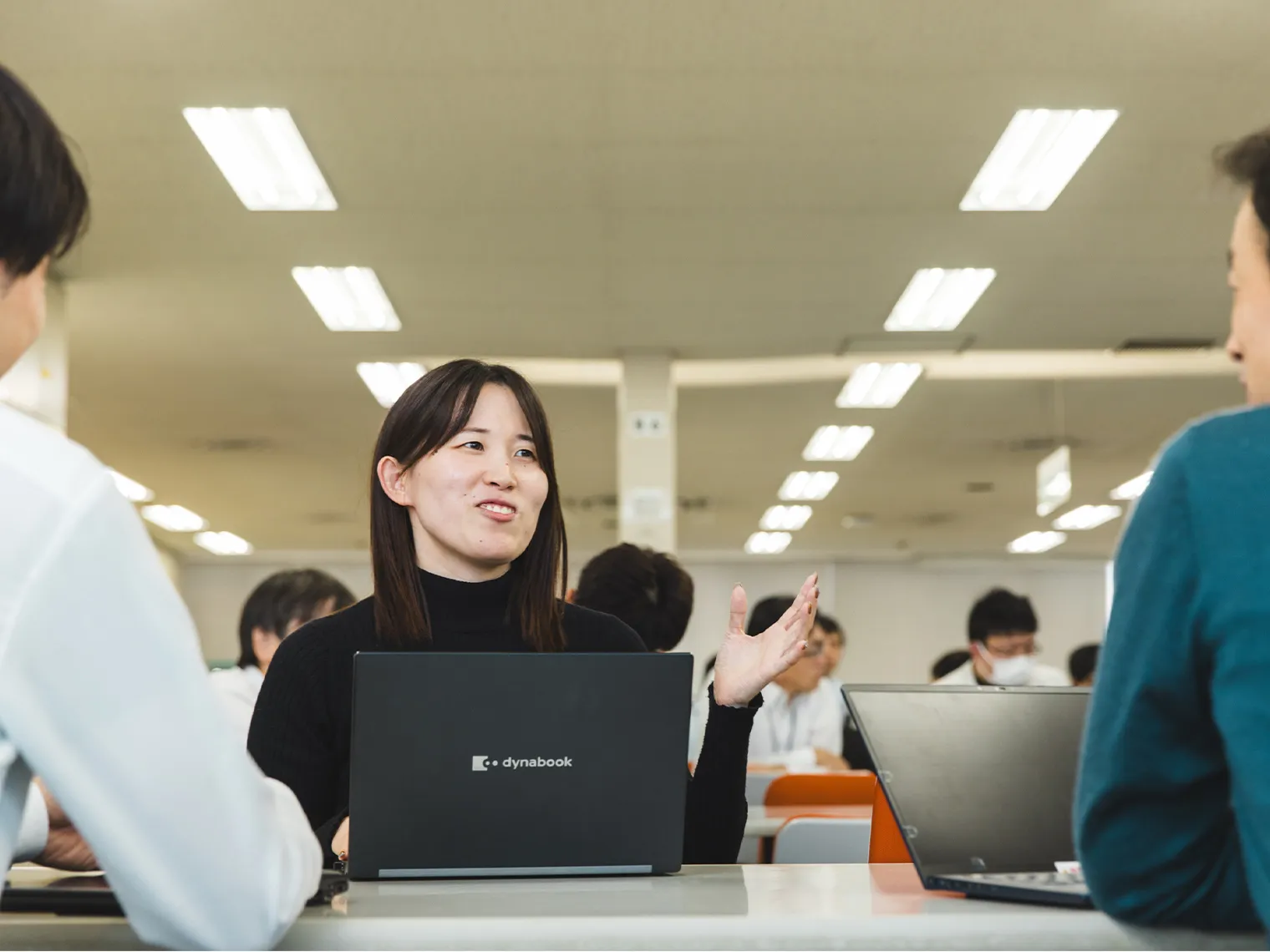 オフィスでノートパソコンを使いながら説明する安部