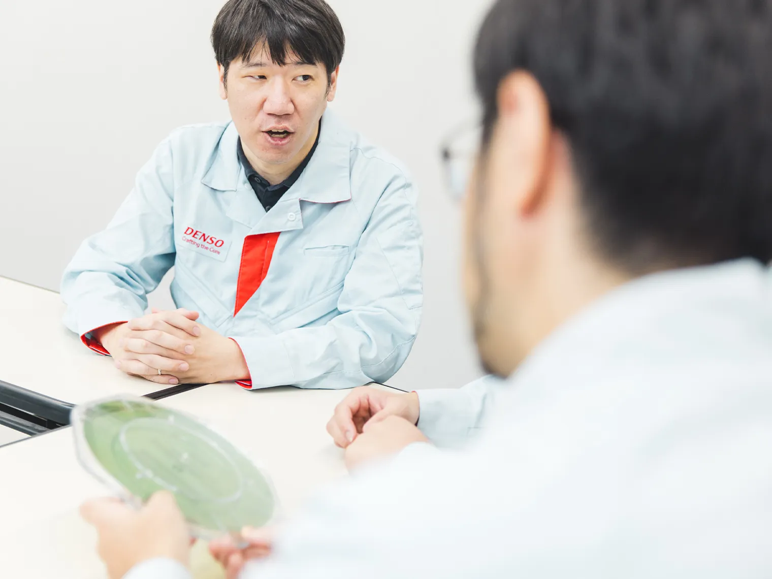 SiCウエハを手にしながら説明する渡辺