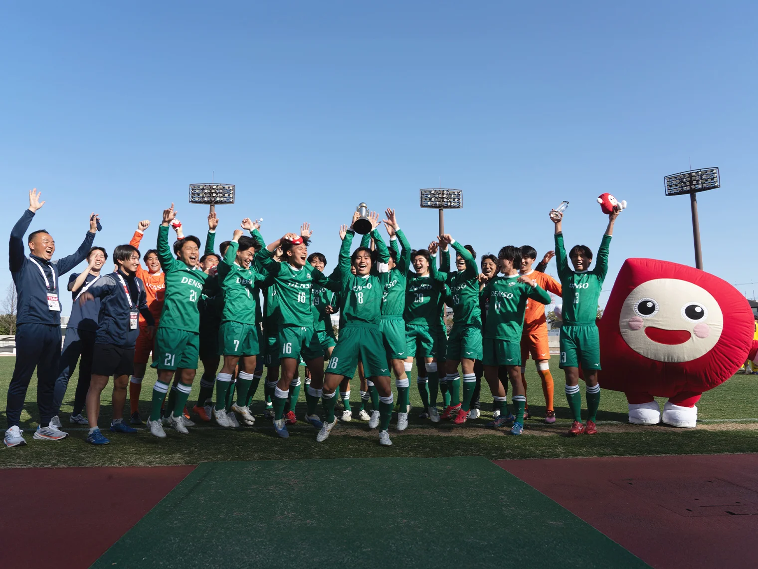 トロフィーを掲げて喜ぶ緑のユニフォームを着た選手たち
