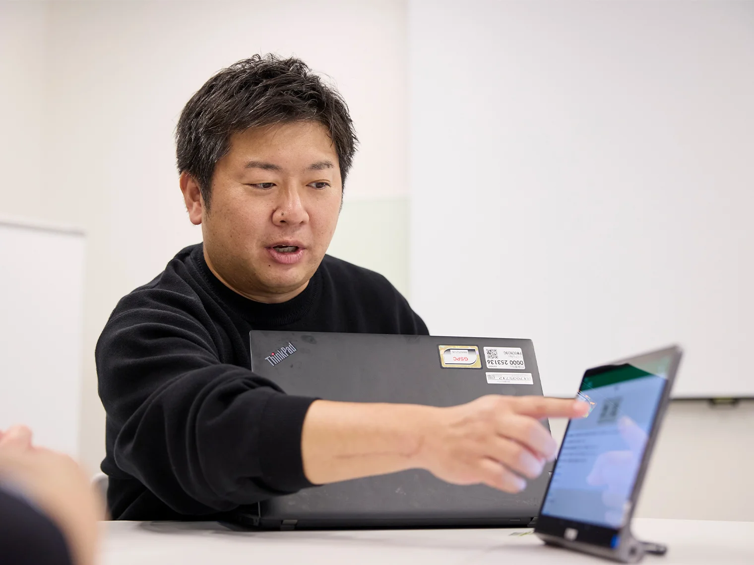 タブレットを指差しながらライフビジョンの説明をする原田