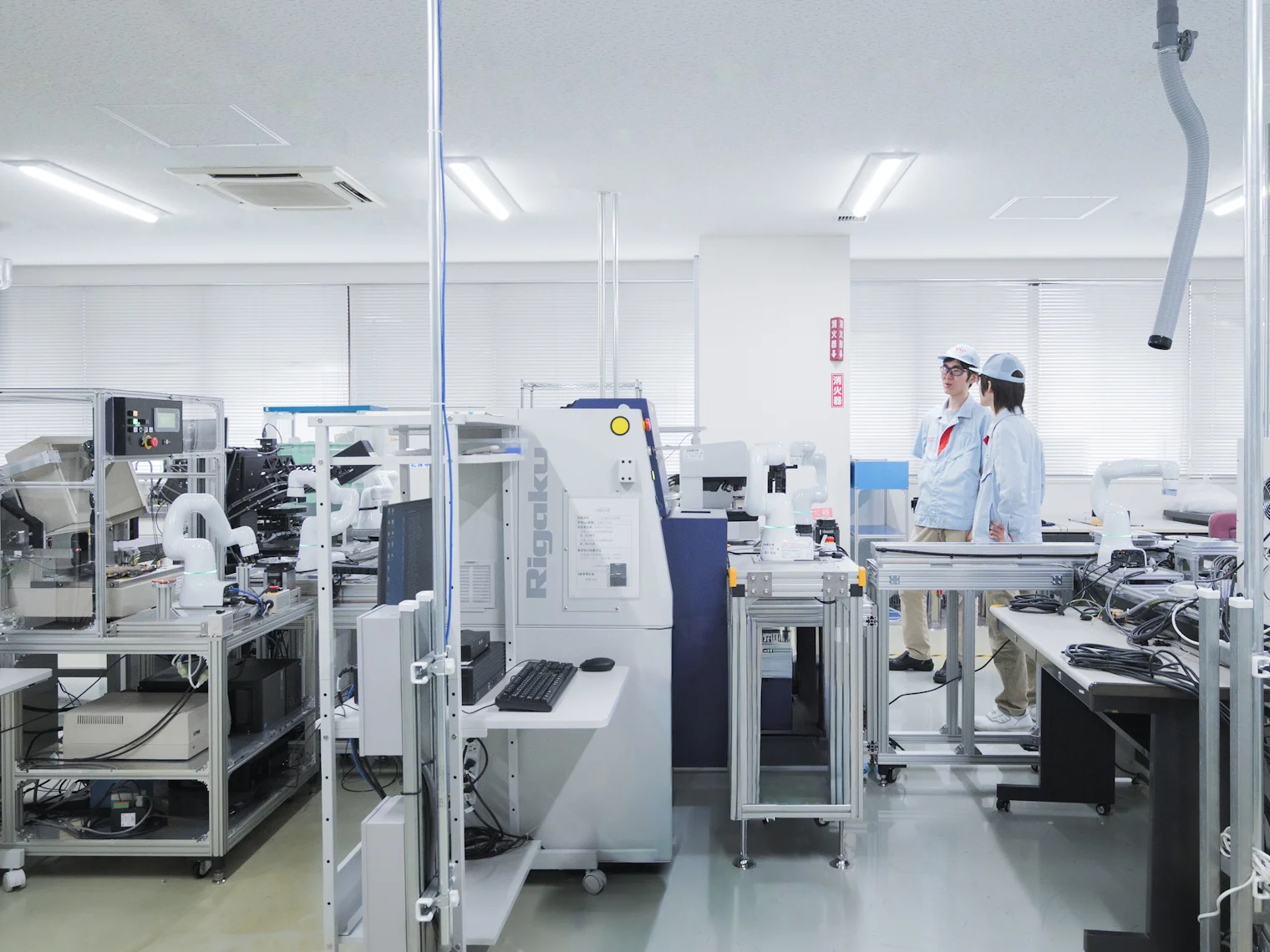 人が見守る中、ロボットがそれぞれ作業を進める様子