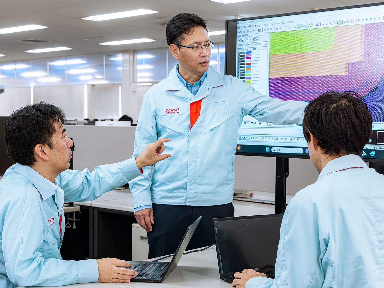 モニターの技術データを議論する伊藤孝浩、三角忠司、山本建策