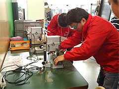 写真は、電動ドリルによる穴あけ作業の様子