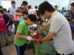 写真は、竹筒の切断作業の様子