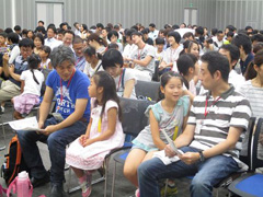 写真は、会社説明を聞く社員と社員家族の様子