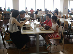 写真は、社員食堂で食事をする社員と社員家族の様子