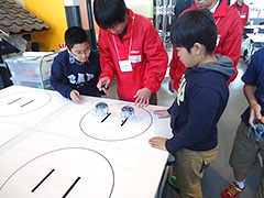写真は、ロボットで相撲をしている様子