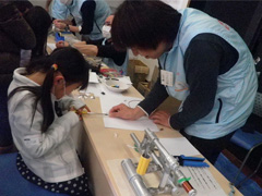 写真は、女の子がドライバーでネジを締めている様子