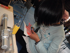 写真は、魚の絵を描きかたに沿って切っている女の子の様子