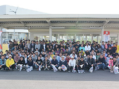 写真は、200名を超える社員とその家族がボランティアとして参加し、集合写真を撮影している様子