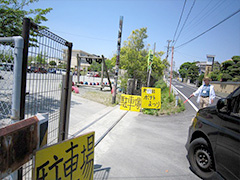 写真は、駐車場の入口に立ち、来場者の車を誘導している様子