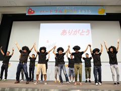 写真は、手をつないでジャンプする、手話サークルメンバーの様子