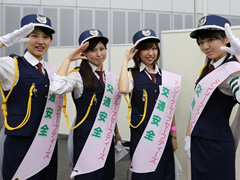 写真は、警察官風の衣装でポーズを決める4名の女性社員の様子