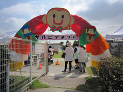 写真は、サルビア学園の門にはおさるさんの飾りがつけられたアーチが準備されており、来場者がくぐっている様子