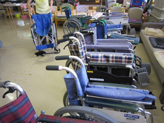 写真は、修理し終えた車いすがズラリと並べられた様子