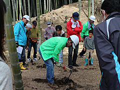 写真は、そうちく会の活動を見学し､タケノコ掘り体験をしている様子