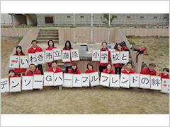 写真は、一文字一文字書かれた「絆」の文字をボランティアが持っている様子