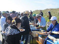 写真は、みんなにカレーライスを配っている様子