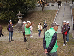 写真は、ガイドのかたより、多賀神社の説明を受ける参加者の様子