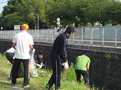 写真は、土手の草刈りや川底の草を集める参加者の様子
