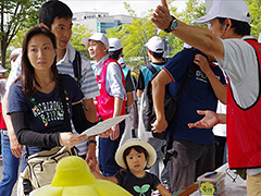 写真は、受付後に、歩くコース地図をもらい説明を聞く様子