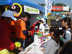 写真は、たくさんの子どもたちへバルーンアートをプレゼントするデンソーグループ社員のボランティアスタッフの様子