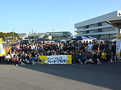 写真は、清掃を開始する前に全員で記念撮影をしている様子。横断幕やのぼりを持ち、約200名の参加者が並んでいます