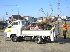 写真は、軽トラックの荷台に回収したゴミが載せられている様子。川底から持ち上げた木やゴミが溢れんばかりに乗っています
