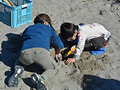 写真は、男の子2人が穴を掘っている様子