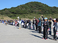 写真は、参加者全員で海岸清掃の前に掛け声をかけている様子