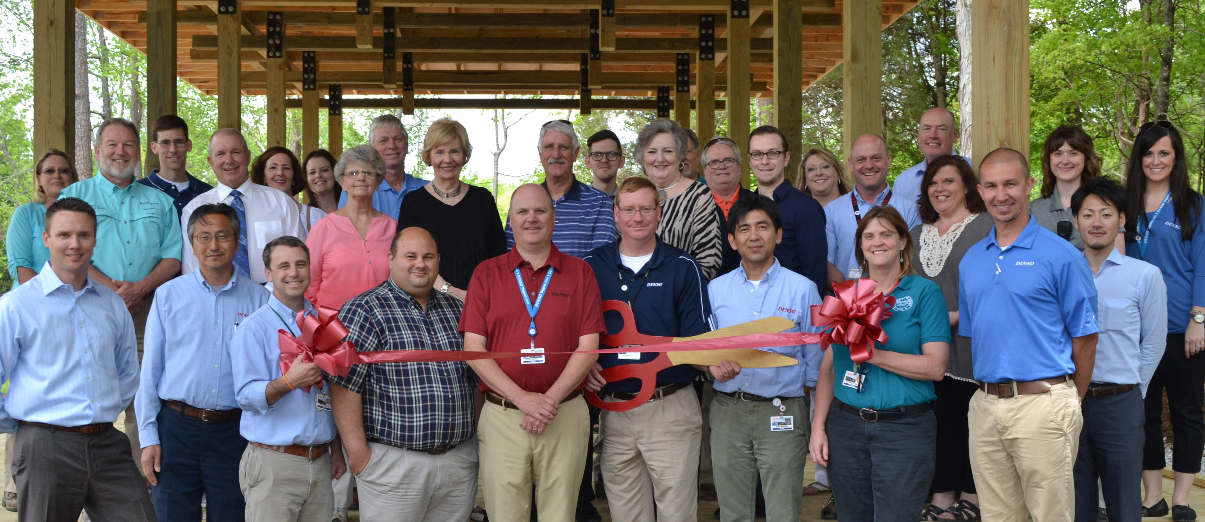 People posing for a ribbon cutting