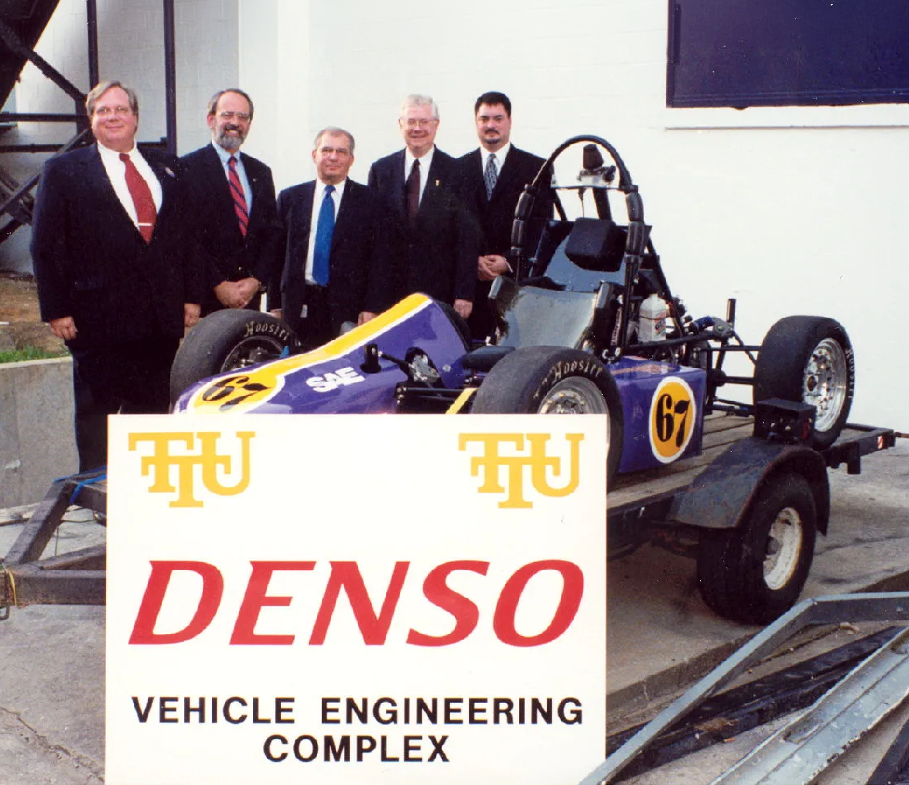 group posing with vehicle