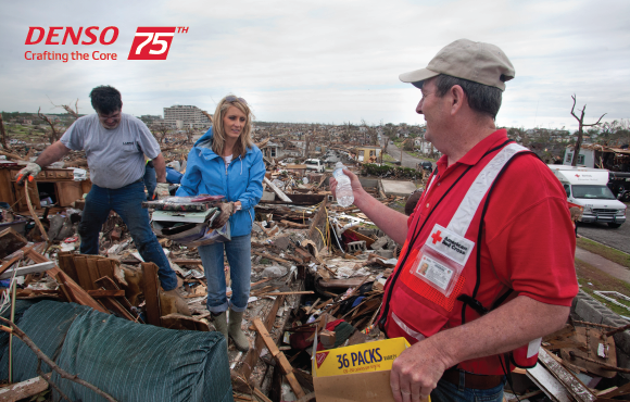 Man hands people water amid tornado's devastation