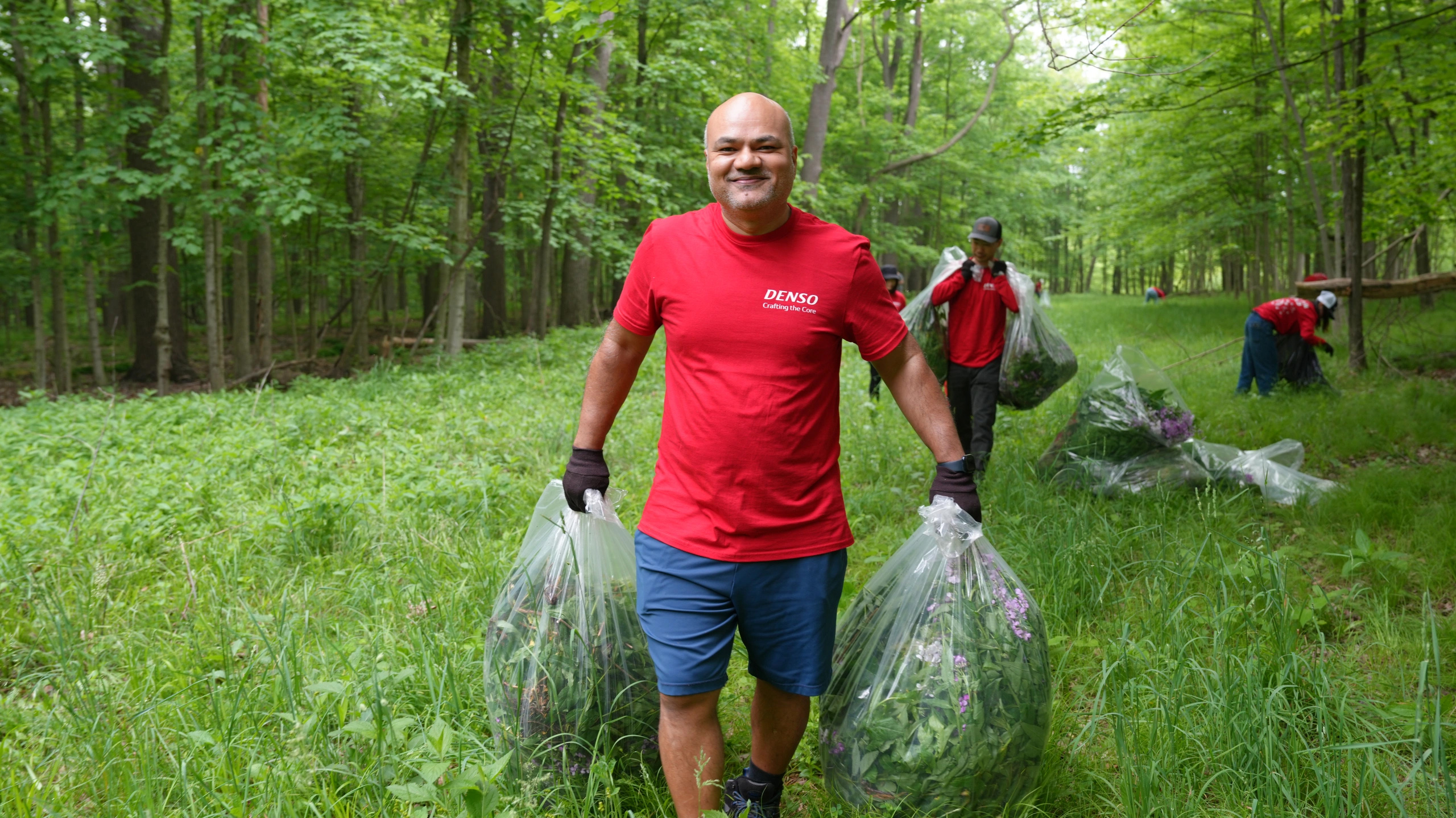 Man Smiles while carrying bags of invasive Species